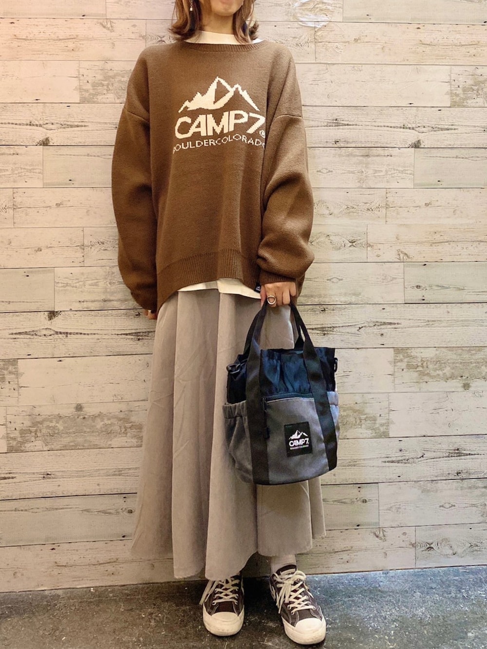 ブラウン系のニット/セーター、グレー系のショルダーバッグ、グレー系のスカートを着用したレディースの秋コーディネートの1枚目の写真