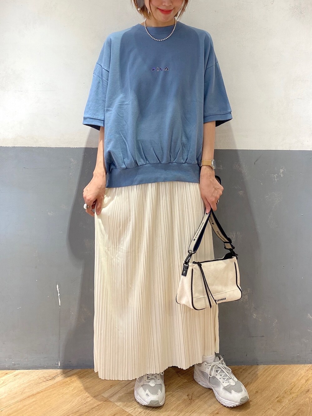 ホワイト系のスカート、ブルー系のTシャツ/カットソー、ホワイト系のショルダーバッグを着用したレディースの春コーディネートの1枚目の写真