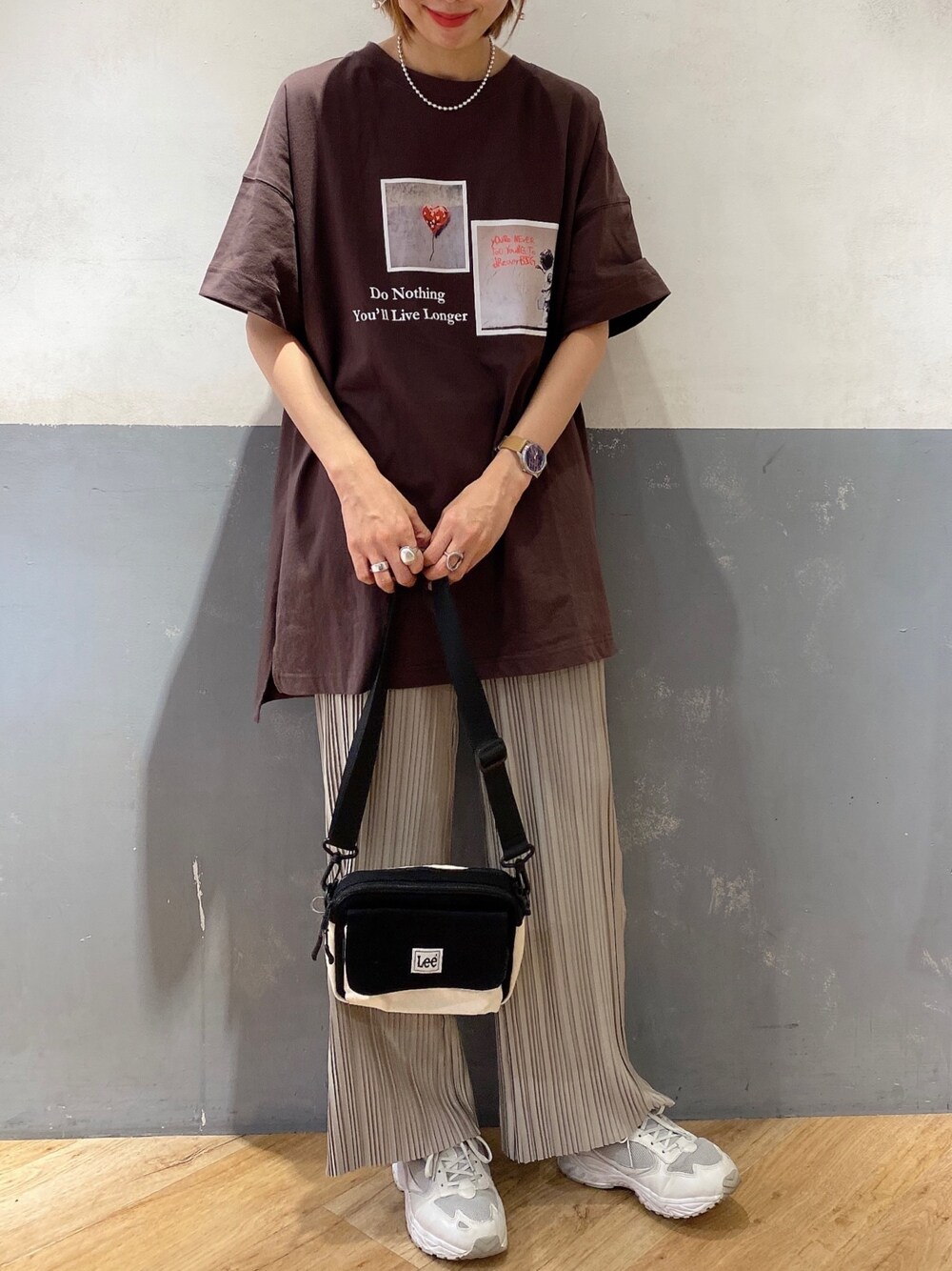 ブラウン系のTシャツ/カットソー、ブラック系のショルダーバッグ、ベージュ系のその他パンツを着用したレディースの春コーディネートの1枚目の写真