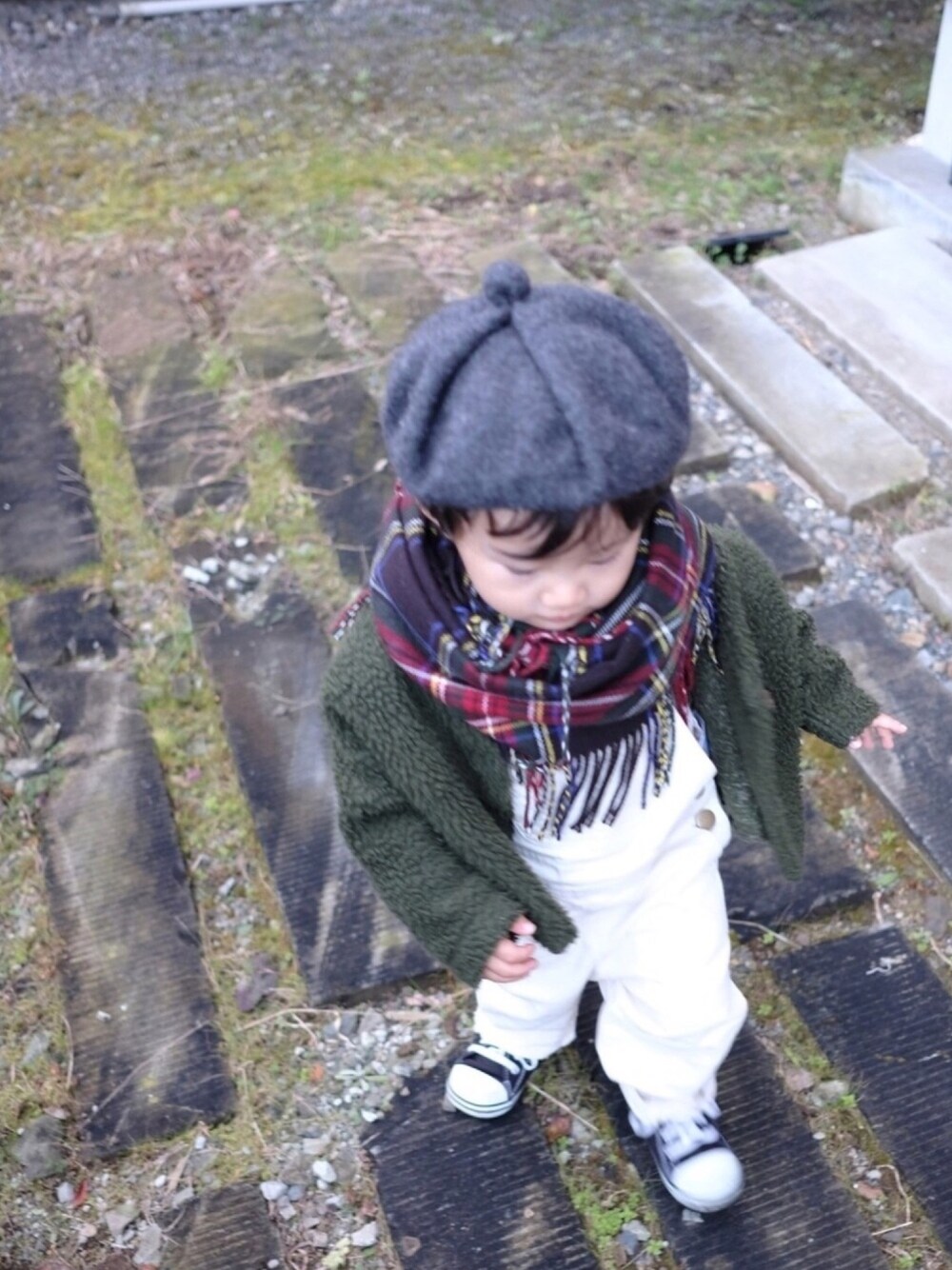 グリーン系のカーディガン/ボレロ、ブルー系のニット/セーター、ブラック系のスニーカーを着用したキッズの冬コーディネートの1枚目の写真