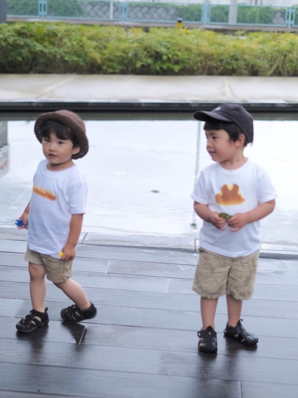 ブラック系のサンダル、ホワイト系のTシャツ/カットソー、ベージュ系のパンツを着用したキッズの夏コーディネートの1枚目の写真