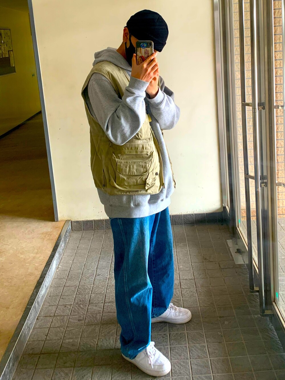 ホワイト系のスニーカー、ブルー系のデニムパンツ、グレー系のパーカーを着用したメンズの春コーディネートの1枚目の写真