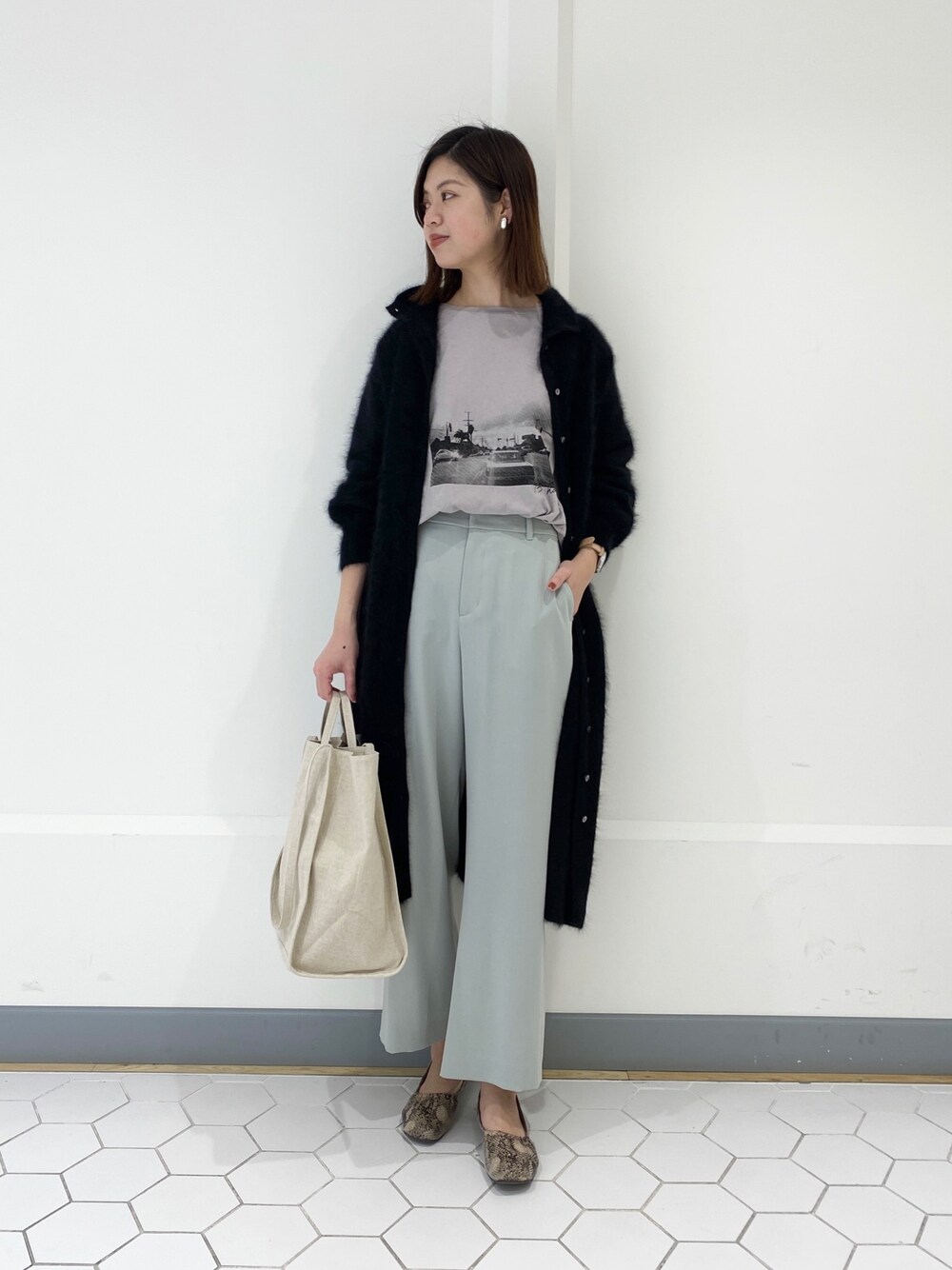 グレー系のTシャツ/カットソー、グリーン系のその他パンツ、ベージュ系のトートバッグを着用したレディースの冬コーディネートの1枚目の写真