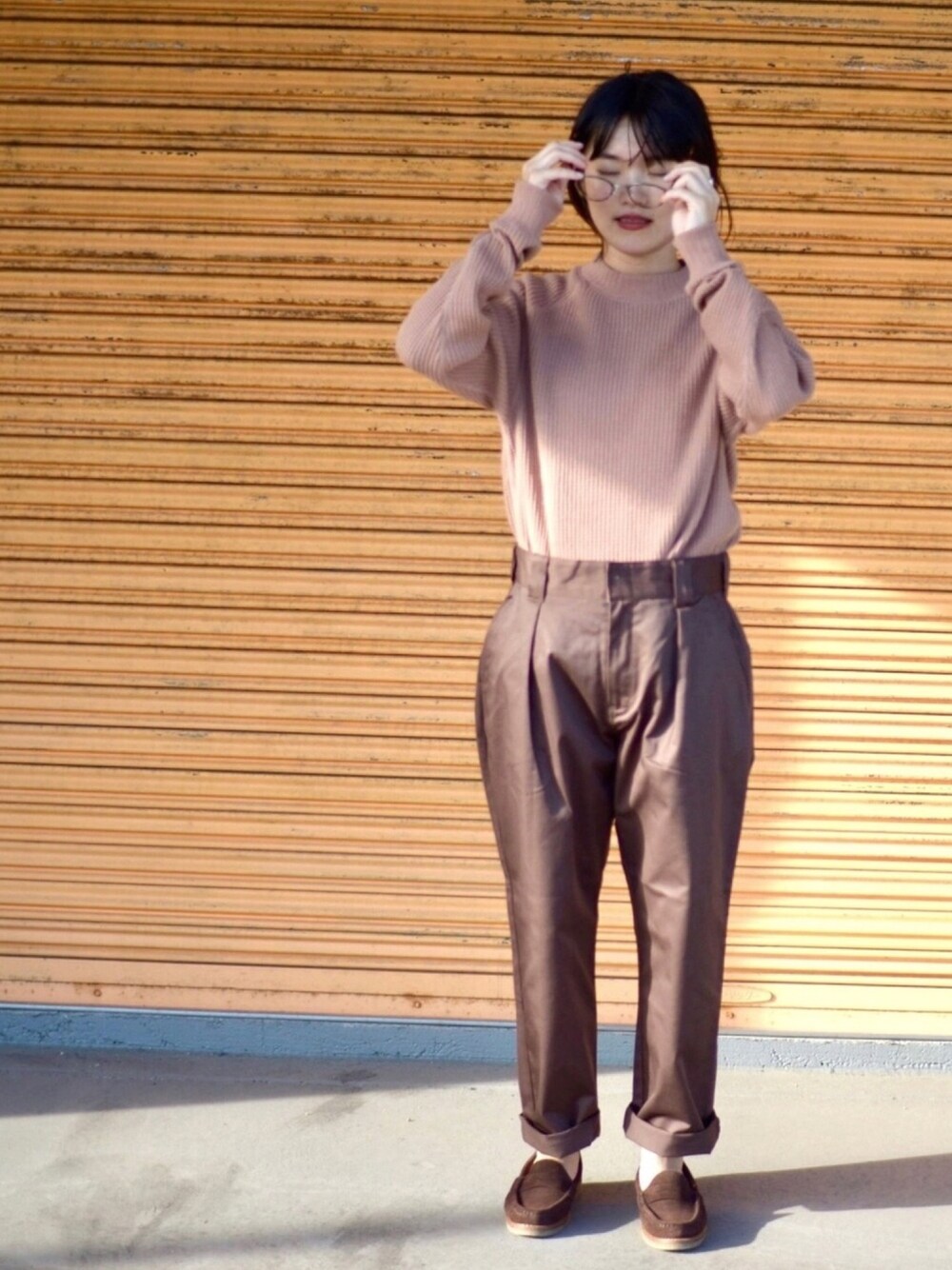 ピンク系のニット/セーター、ブラウン系のパンツ、ブラウン系のローファーを着用したレディースの秋コーディネートの1枚目の写真