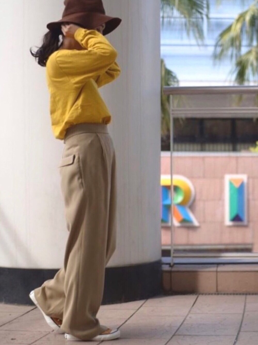 イエロー系のTシャツ/カットソー、ブラウン系のパンツ、イエロー系のスニーカーを着用したレディースの春コーディネートの1枚目の写真