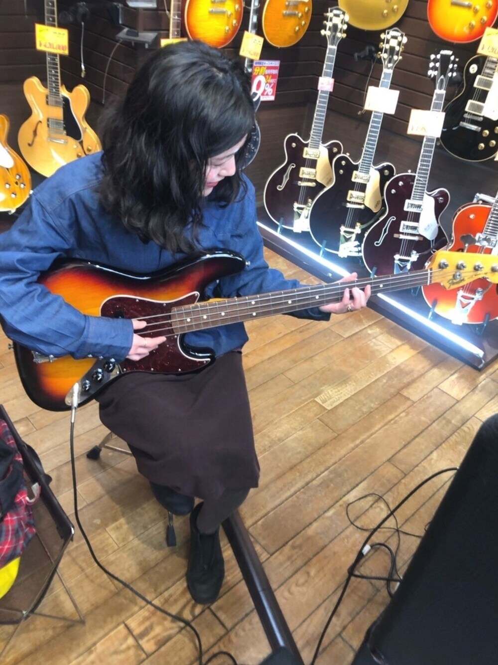 ブルー系のシャツ/ブラウス、パープル系のワンピース/ドレス、ブラック系のスニーカーを着用したレディースの春コーディネートの1枚目の写真