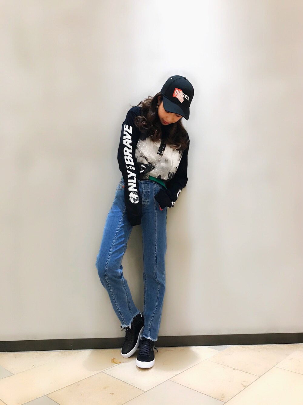 ブラック系のTシャツ/カットソー、ブルー系のデニムパンツ、ブラック系のスニーカーを着用したレディースの冬コーディネートの1枚目の写真