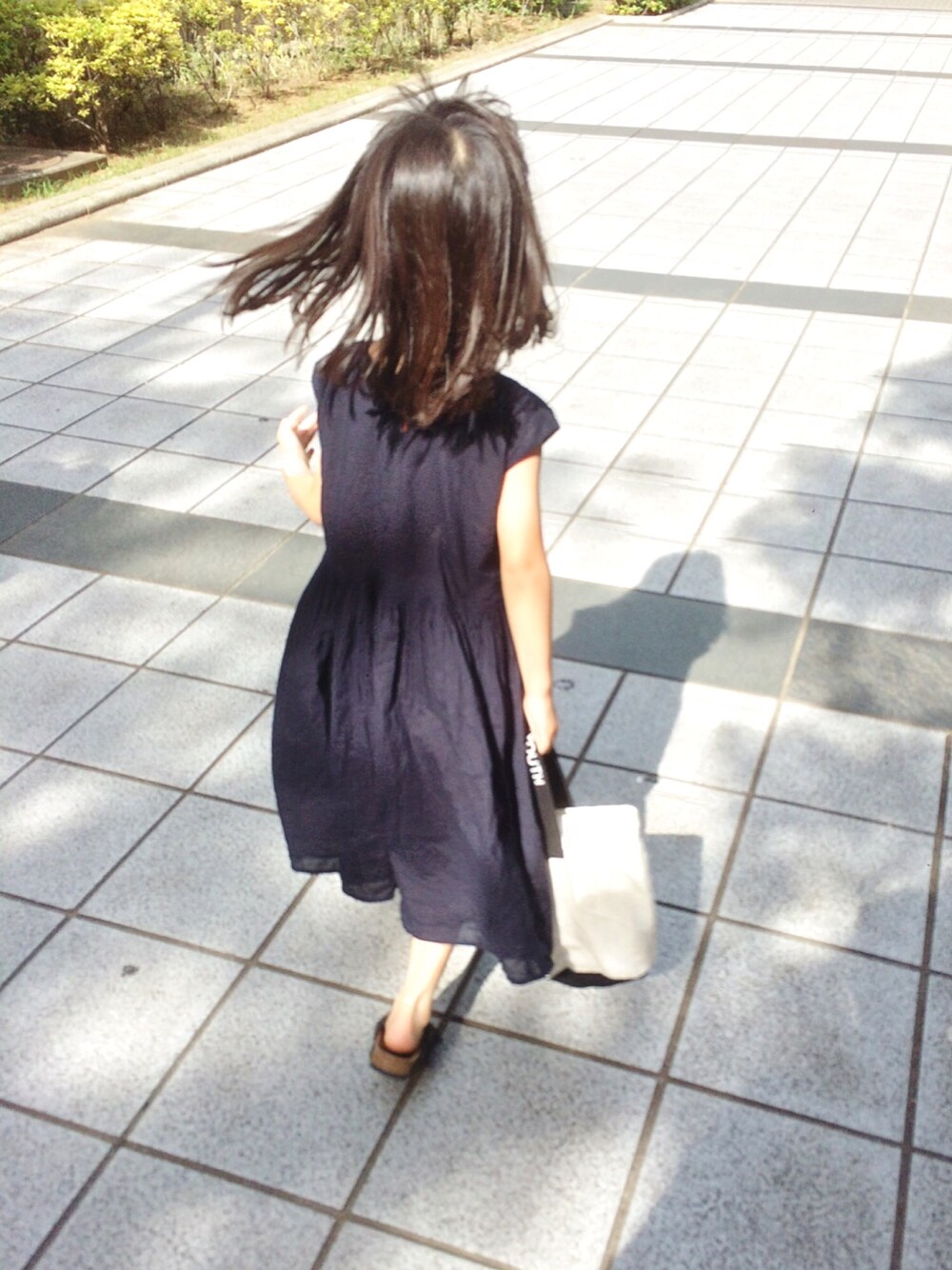 ブルー系のワンピース、ブラック系のサンダル、ブラック系のトートバッグを着用したキッズの夏コーディネートの1枚目の写真