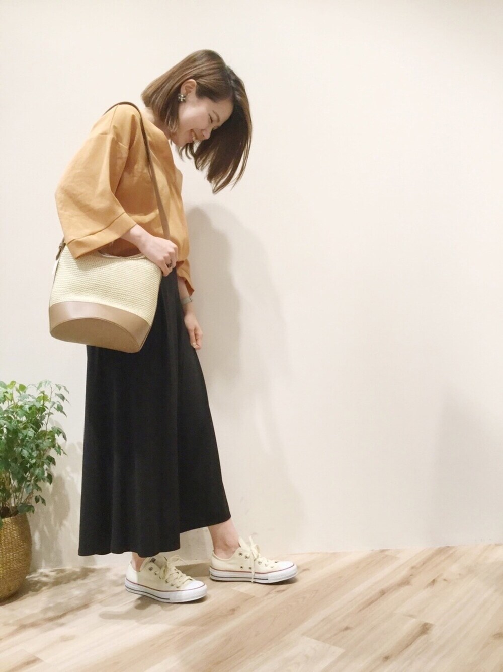 グリーン系のワンピース、ベージュ系のスニーカー、オレンジ系のシャツ/ブラウスを着用したレディースの夏コーディネートの1枚目の写真