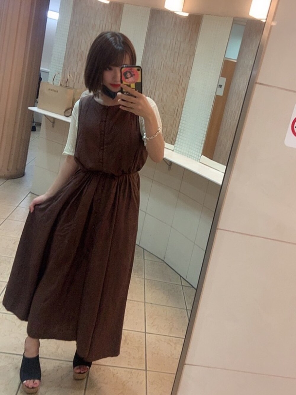 ブラウン系のワンピース、ホワイト系のニット/セーター、ブラック系のサンダルを着用したレディースの夏コーディネートの1枚目の写真