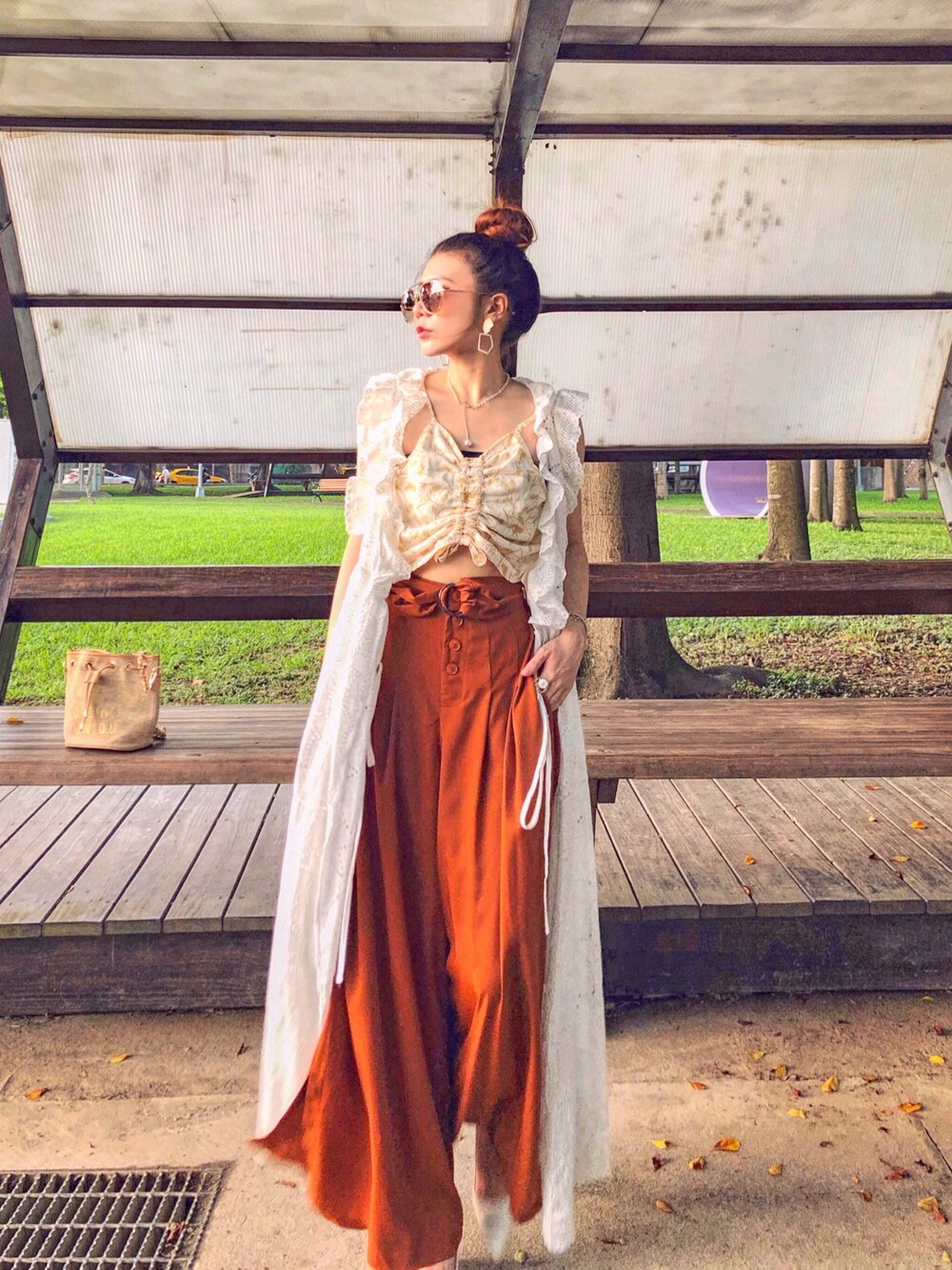 オレンジ系のチノパンツを着用したレディースの秋コーディネートの1枚目の写真