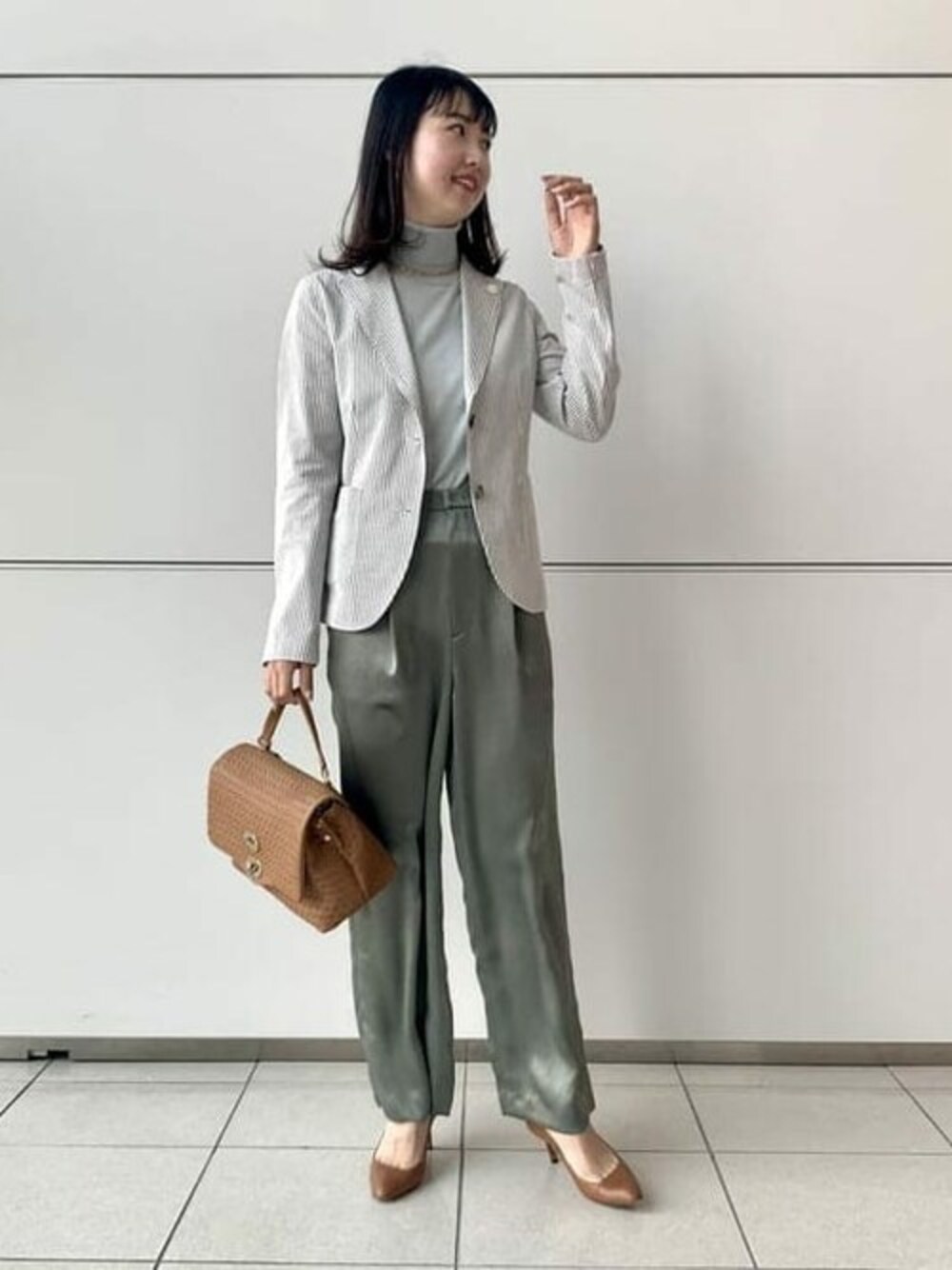 ベージュ系のテーラードジャケット、ブルー系のニット/セーター、グリーン系のその他パンツを着用したレディースの春コーディネートの1枚目の写真