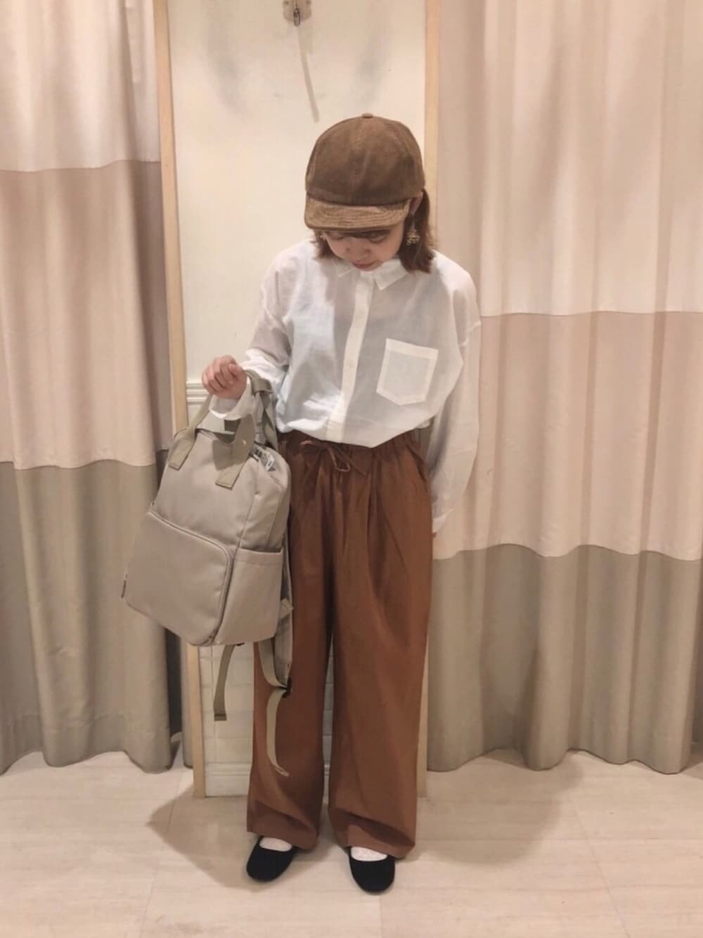 ブラウン系のその他パンツ、ベージュ系のバックパック/リュック、ホワイト系のシャツ/ブラウスを着用したレディースの夏コーディネートの1枚目の写真