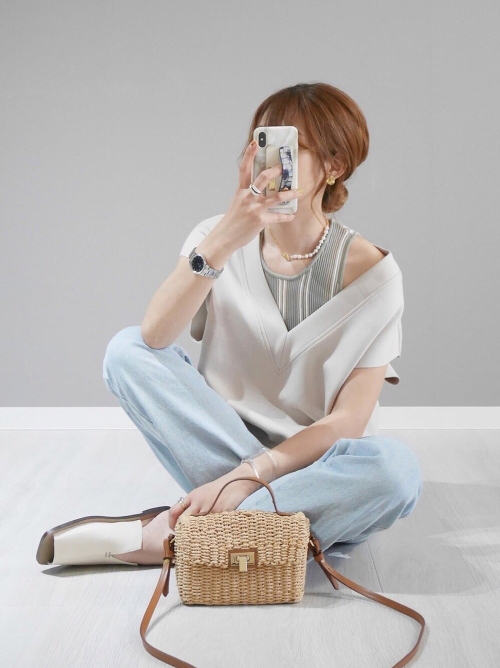 ベージュ系のベスト、グリーン系のTシャツ/カットソー、ホワイト系のサンダルを着用したレディースの春コーディネートの1枚目の写真