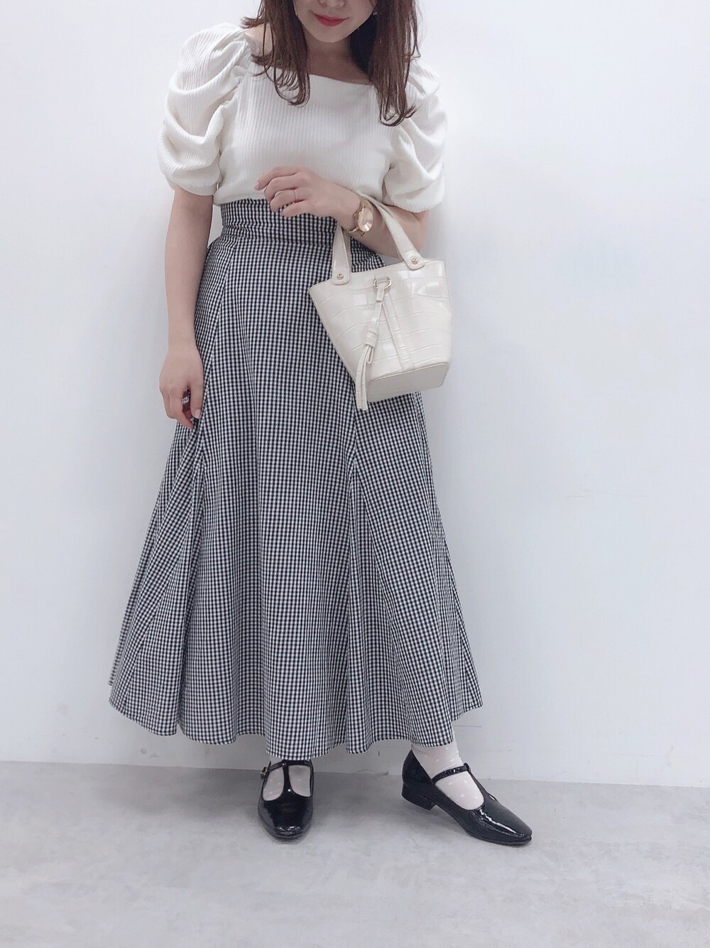 その他のスカート、ホワイト系のTシャツ/カットソー、ホワイト系のハンドバッグを着用したレディースの春コーディネートの1枚目の写真