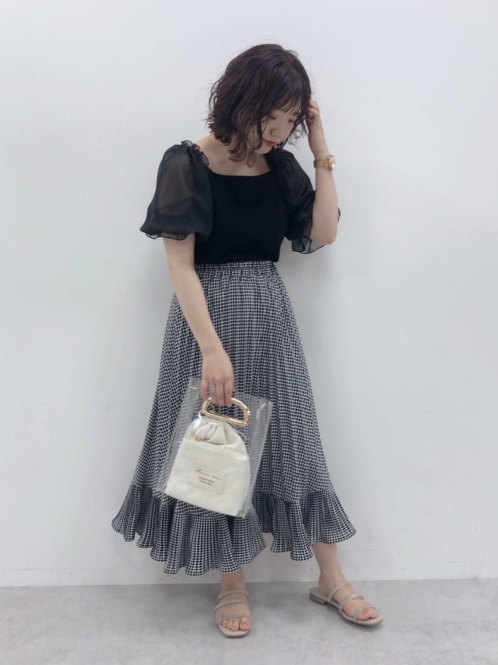 ブラック系のTシャツ/カットソー、その他のスカート、ホワイト系のショルダーバッグを着用したレディースの春コーディネートの1枚目の写真