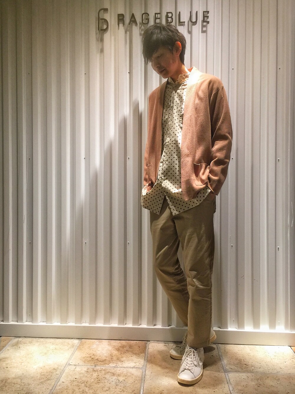 ベージュ系のニット/セーター、ブルー系のシャツ/ブラウス、ベージュ系のチノパンツを着用したメンズの春コーディネートの1枚目の写真