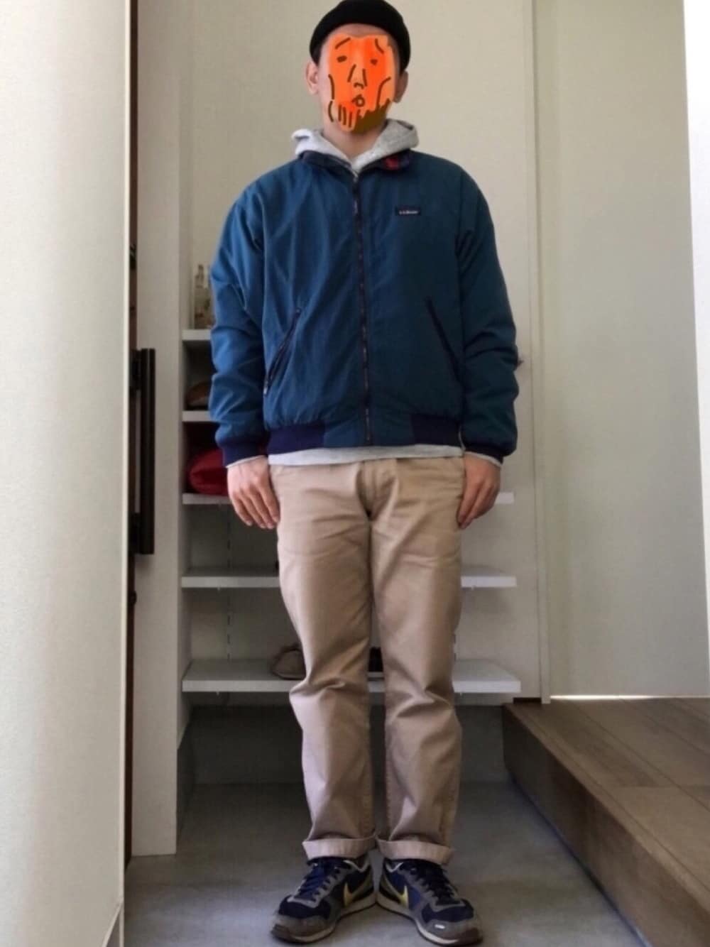 ブルー系のブルゾン、グレー系のパーカー、ベージュ系のチノパンツを着用したメンズの冬コーディネートの1枚目の写真