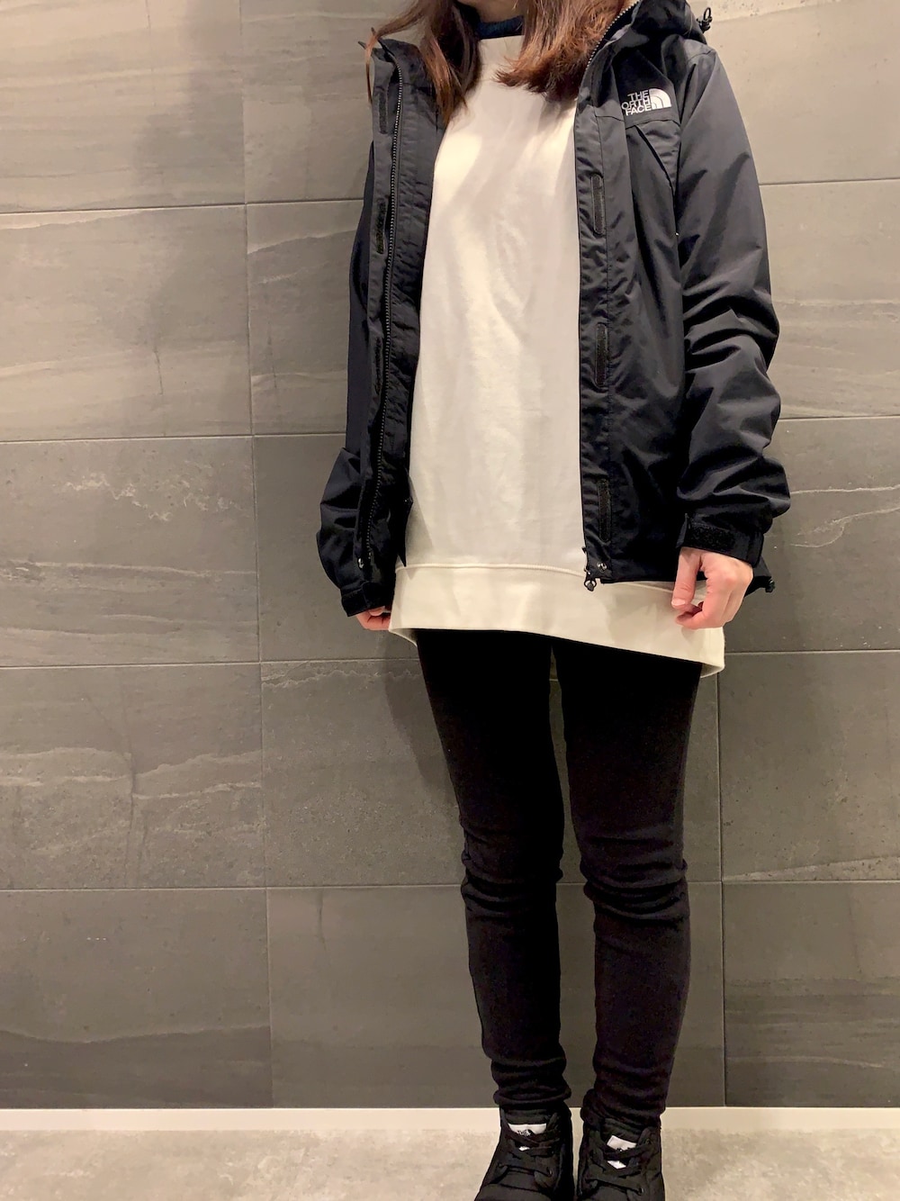 ブラック系のマウンテンパーカー、ホワイト系のTシャツ/カットソー、ブラック系のその他パンツを着用したレディースの春コーディネートの1枚目の写真