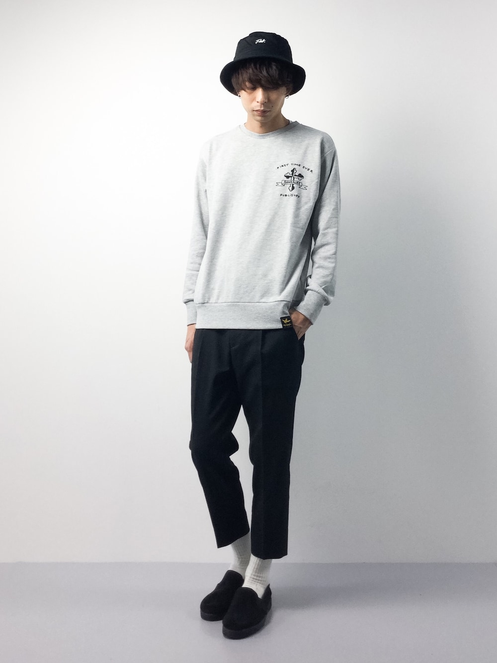 グレー系のTシャツ/カットソー、ブラック系のスラックス、ブラック系のスリッポンを着用したメンズの冬コーディネートの1枚目の写真