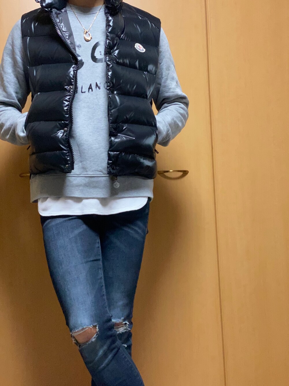 ブラック系のダウンベスト、グレー系のスウェット、ブラック系のデニムパンツを着用したメンズの冬コーディネートの1枚目の写真