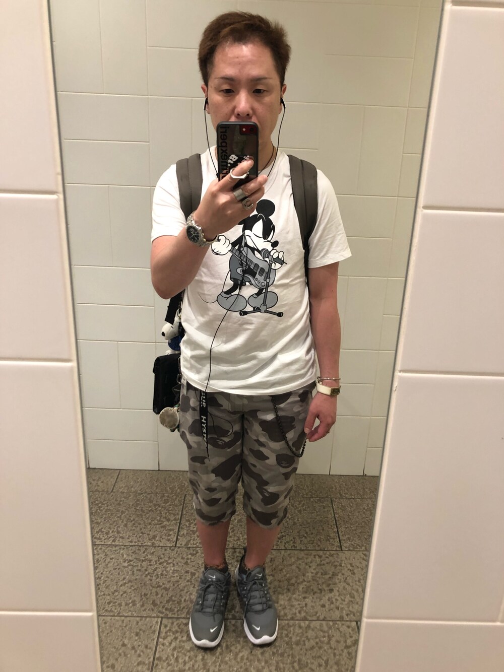 ホワイト系のTシャツ/カットソー、グレー系のバックパック/リュック、グレー系のパンツを着用したメンズの夏コーディネートの1枚目の写真