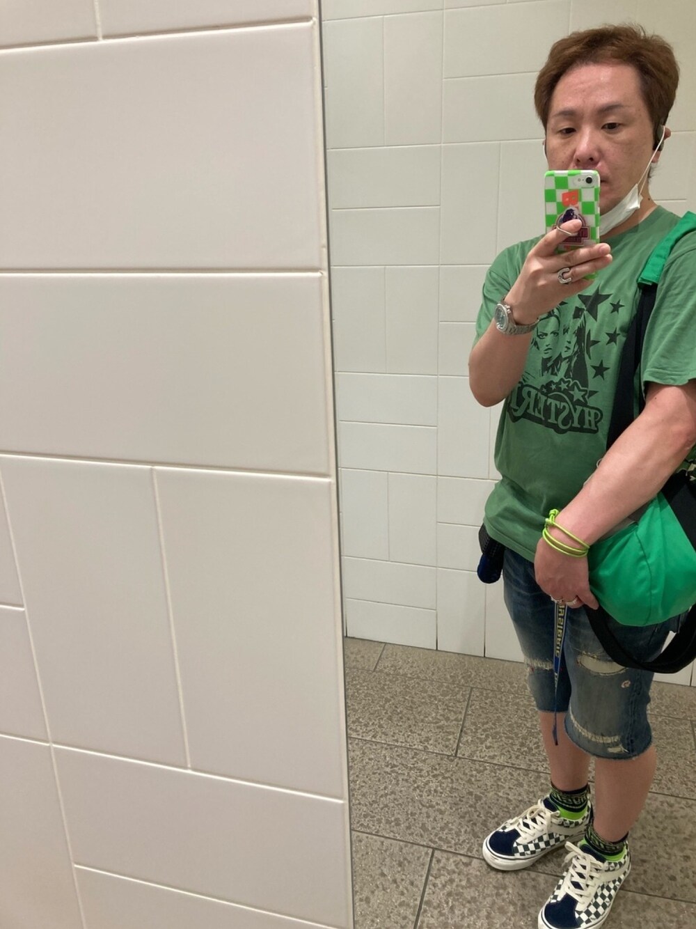 グリーン系のTシャツ/カットソー、グリーン系のドラムバッグ、ブルー系のデニムパンツを着用したメンズの夏コーディネートの1枚目の写真