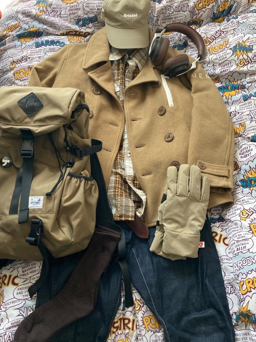 ベージュ系のピーコート、ブラウン系のシャツ/ブラウス、ベージュ系のバックパック/リュックを着用したメンズの春コーディネートの1枚目の写真