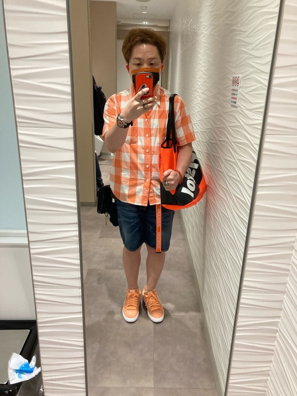 オレンジ系のシャツ/ブラウス、オレンジ系のトートバッグ、ブルー系のデニムパンツを着用したメンズの夏コーディネートの1枚目の写真