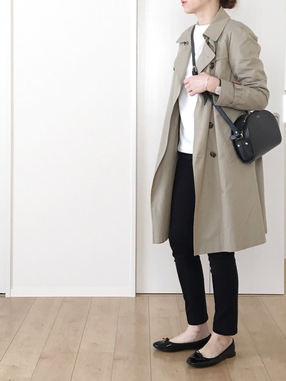 ベージュ系のトレンチコート、ホワイト系のTシャツ/カットソー、ブラック系のバレエシューズを着用したレディースの春コーディネートの1枚目の写真