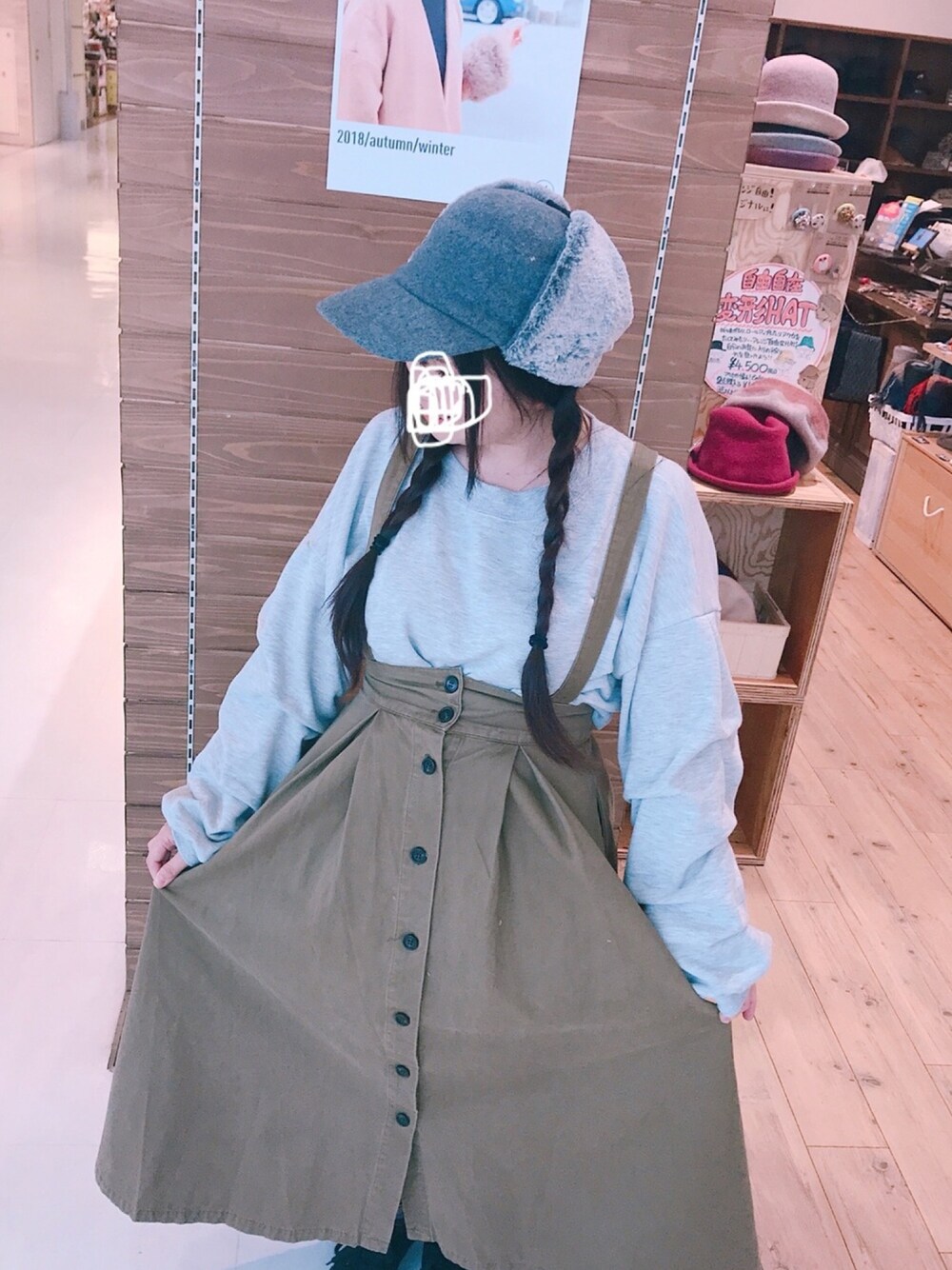 グレー系のTシャツ/カットソー、グリーン系のスカート、グレー系の帽子を着用したレディースの秋コーディネートの1枚目の写真