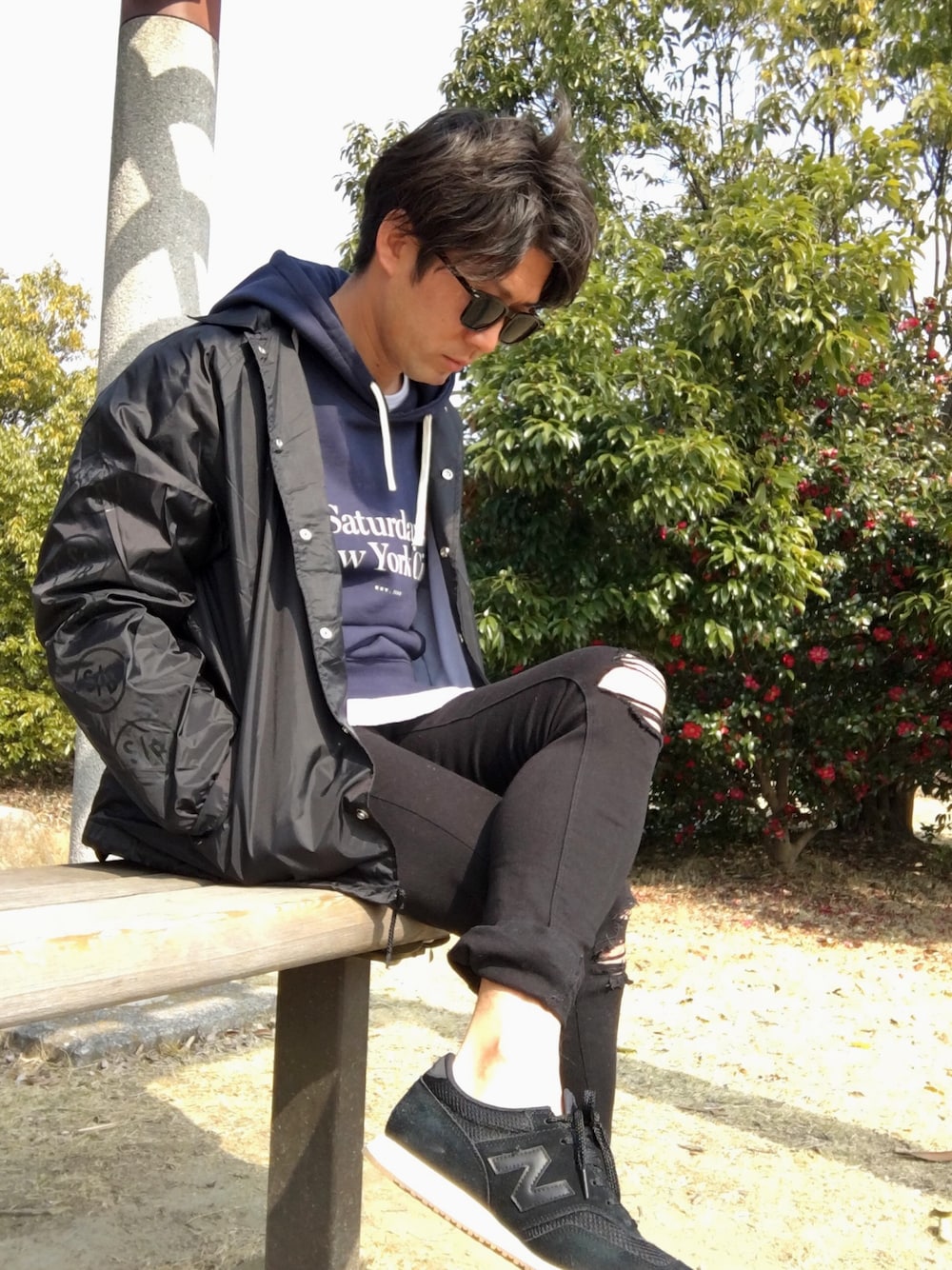 ブラック系のナイロンジャケット、ブルー系のパーカー、ホワイト系のTシャツ/カットソーを着用したメンズの冬コーディネートの1枚目の写真