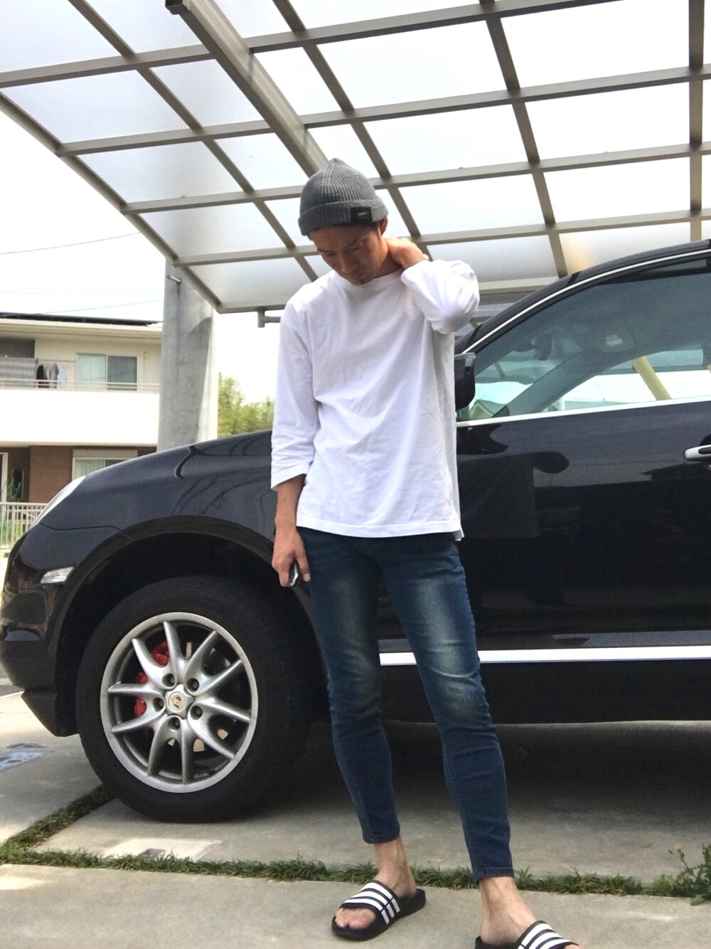 ホワイト系のTシャツ/カットソー、ブルー系のデニムパンツ、ブラック系のサンダルを着用したメンズの春コーディネートの1枚目の写真