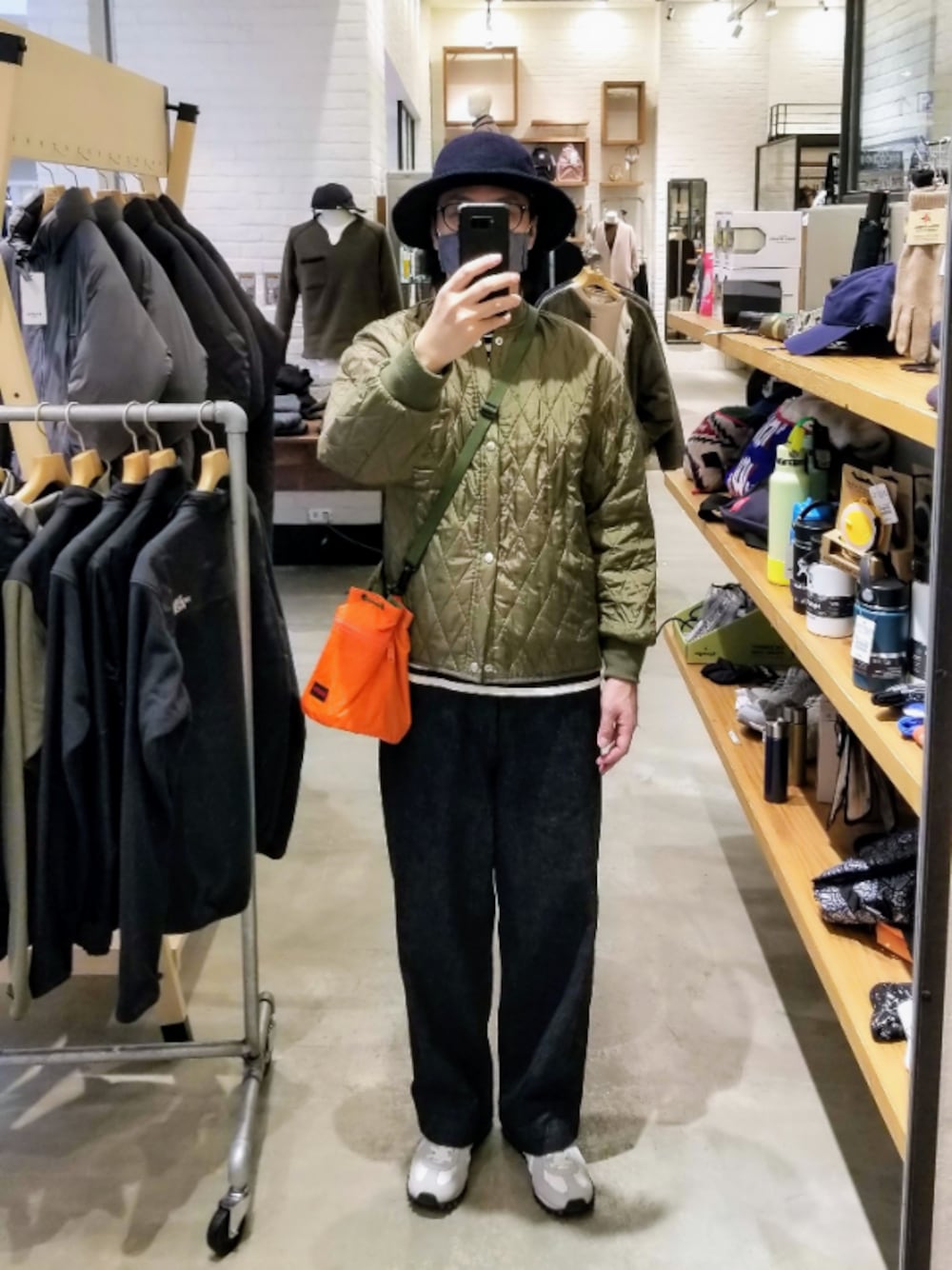 グリーン系のブルゾン、ブルー系のデニムパンツ、ホワイト系のスニーカーを着用したメンズの秋コーディネートの1枚目の写真