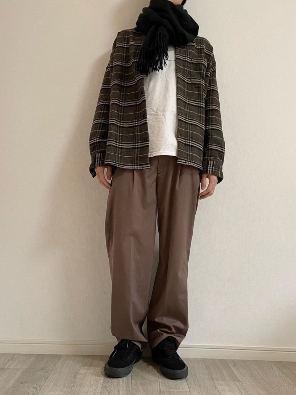 ブラック系のスニーカー、ホワイト系のTシャツ/カットソー、ブラウン系のジャケット/アウターを着用したメンズの冬コーディネートの1枚目の写真