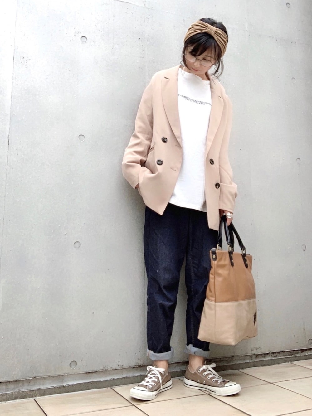 ベージュ系のテーラードジャケット、ホワイト系のTシャツ/カットソー、ブルー系のデニムパンツを着用したレディースの秋コーディネートの1枚目の写真