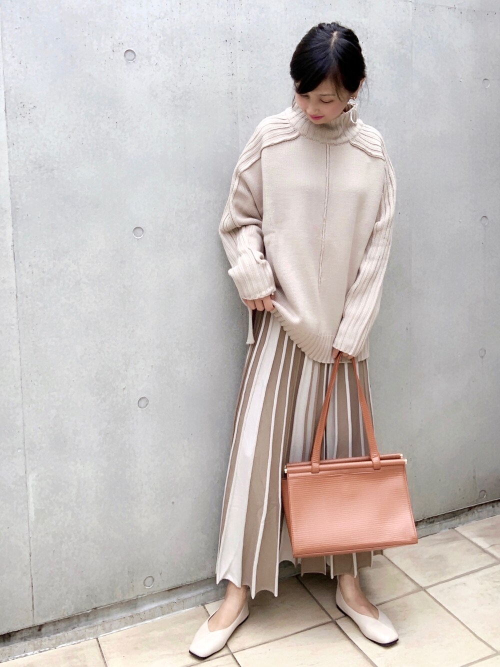 ベージュ系のニット/セーター、ベージュ系のスカート、ホワイト系のバレエシューズを着用したレディースの秋コーディネートの1枚目の写真