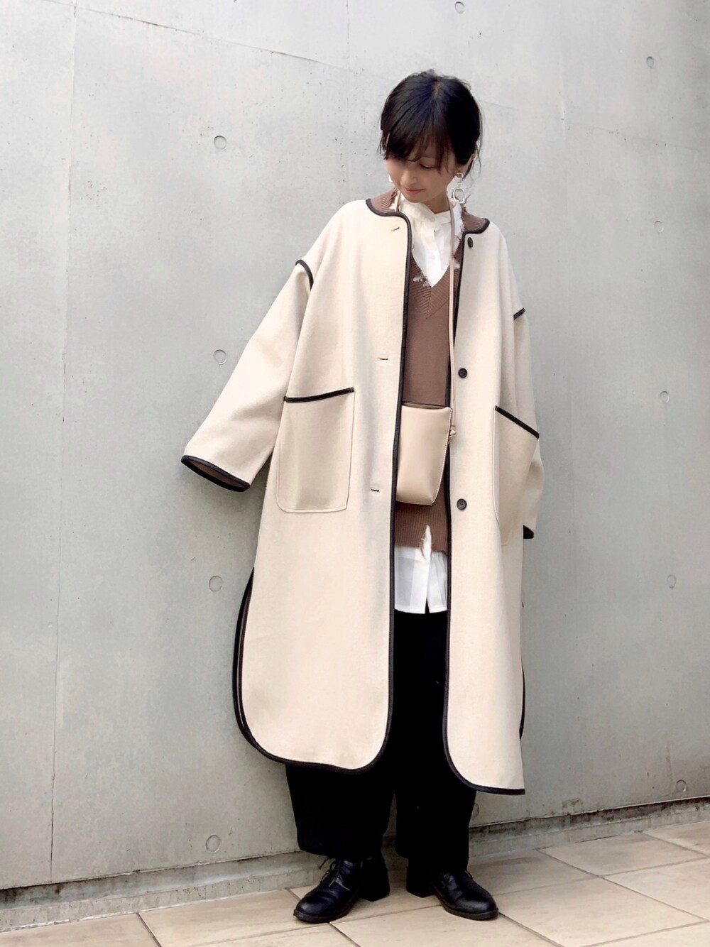 ベージュ系のその他アウター、ブラック系のチノパンツ、ホワイト系のシャツ/ブラウスを着用したレディースの秋コーディネートの1枚目の写真