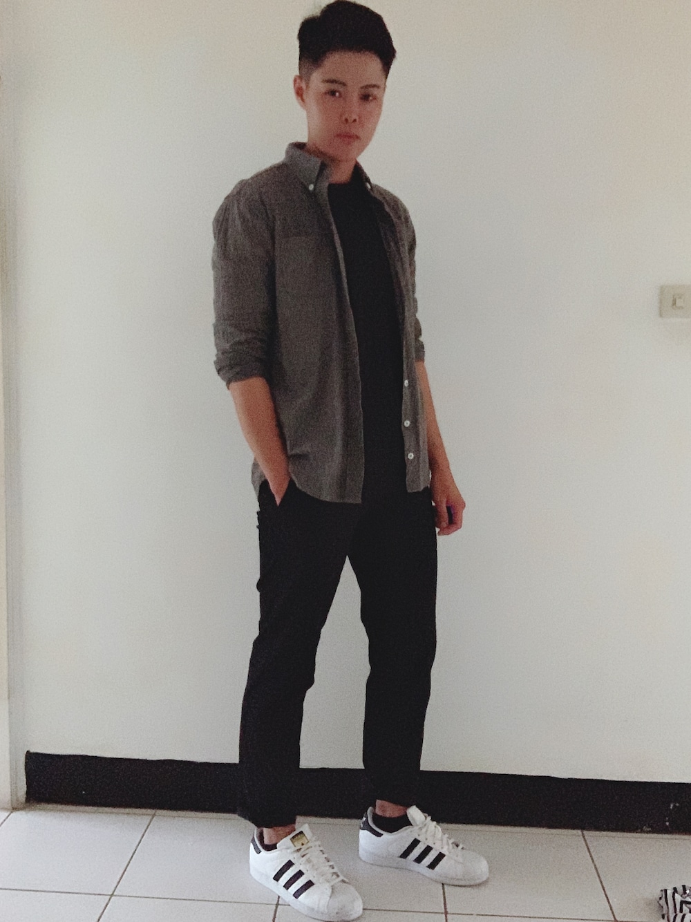 グレー系のシャツ/ブラウス、ブラック系のスラックス、ホワイト系のスニーカーを着用したメンズの秋コーディネートの1枚目の写真