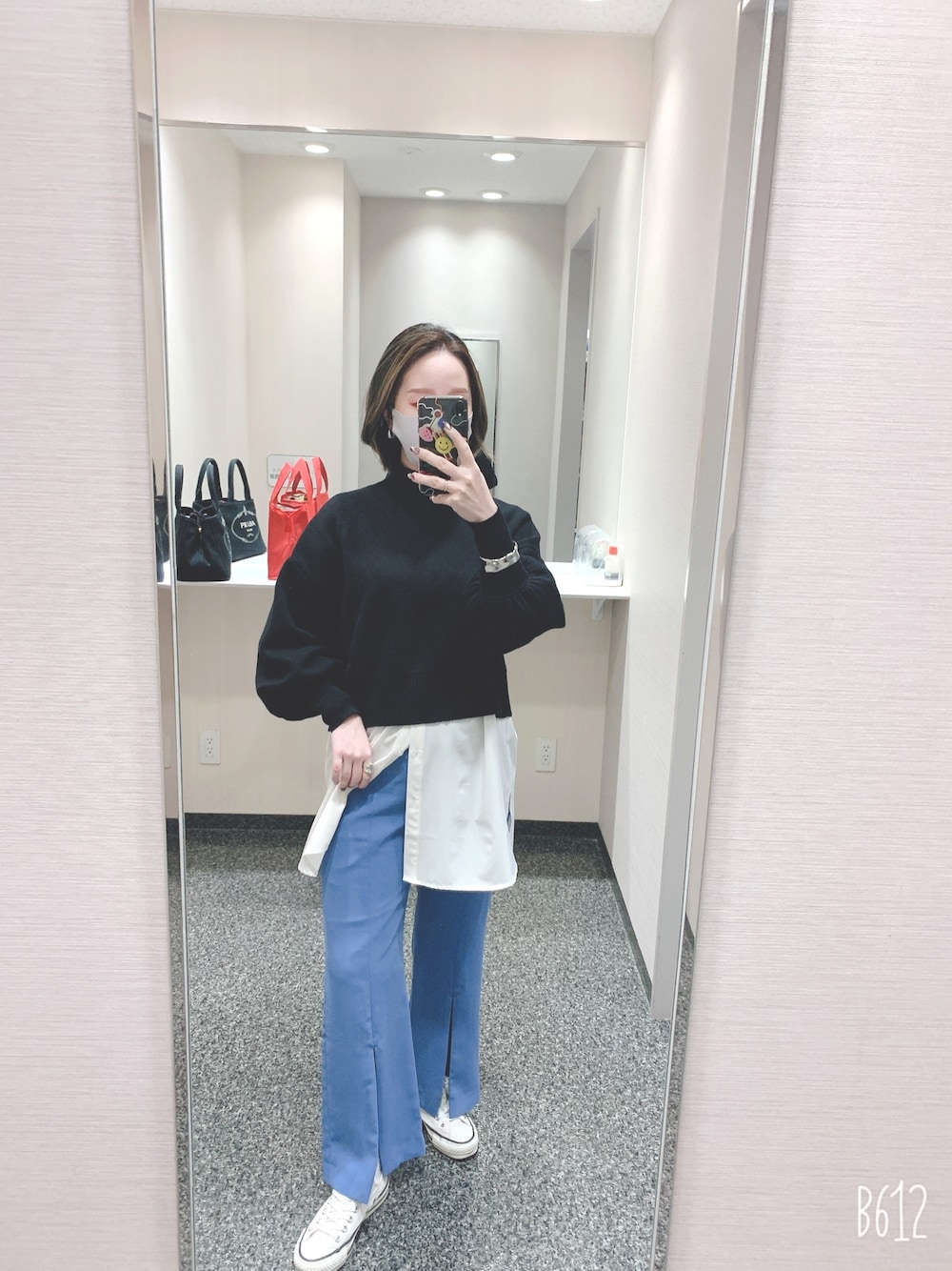 ブラック系のニット/セーター、ブルー系のその他パンツ、ホワイト系のスニーカーを着用したレディースの冬コーディネートの1枚目の写真