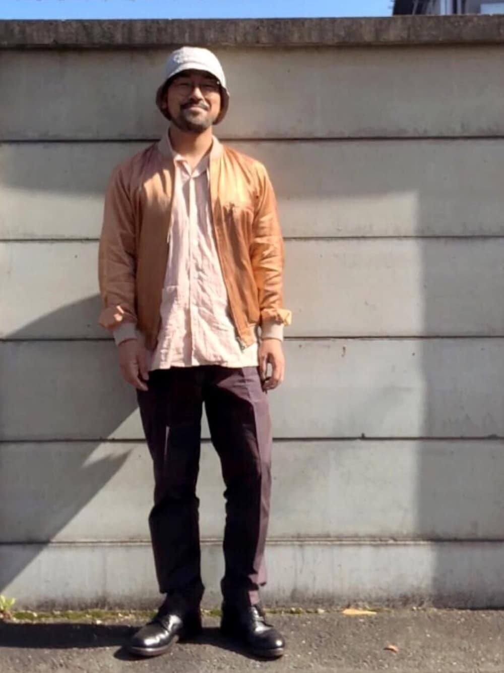 ピンク系のMA-1、ピンク系のトップス、ブラウン系のスラックスを着用したメンズの秋コーディネートの1枚目の写真