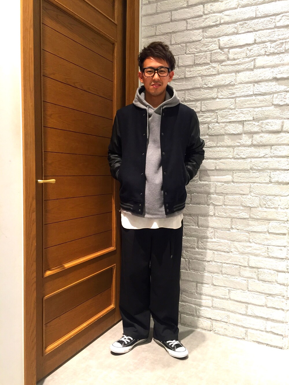 ホワイト系のTシャツ/カットソー、グレー系のパーカー、ブルー系のスタジャンを着用したメンズの冬コーディネートの1枚目の写真