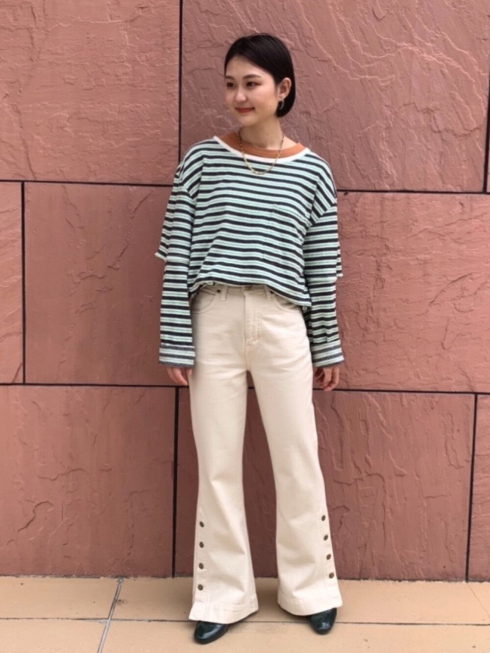 ホワイト系のデニムパンツを着用したレディースの春コーディネートの1枚目の写真