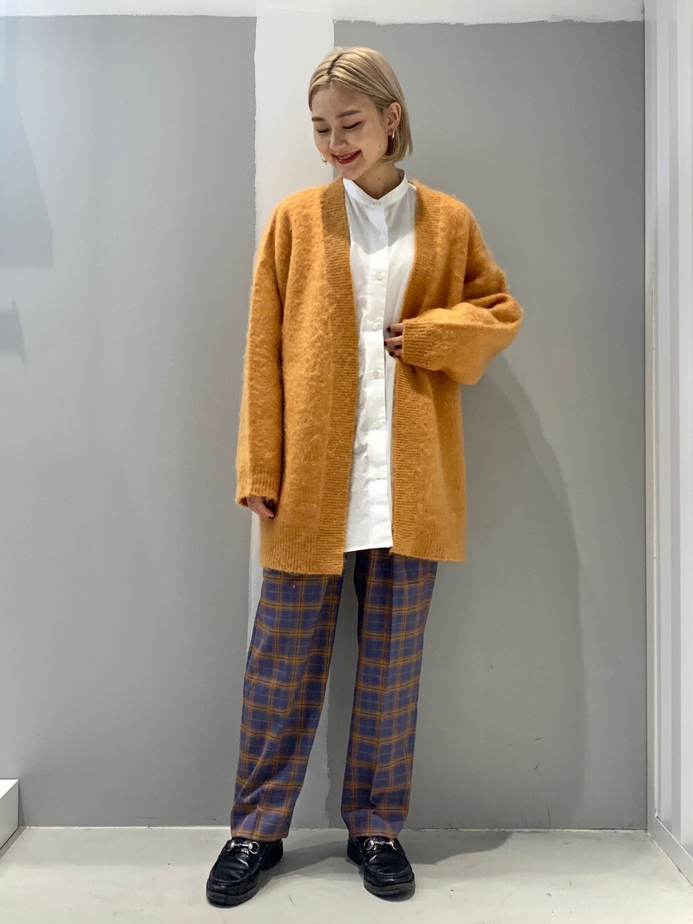 オレンジ系のトップス、ブルー系のその他パンツを着用したレディースの秋コーディネートの1枚目の写真