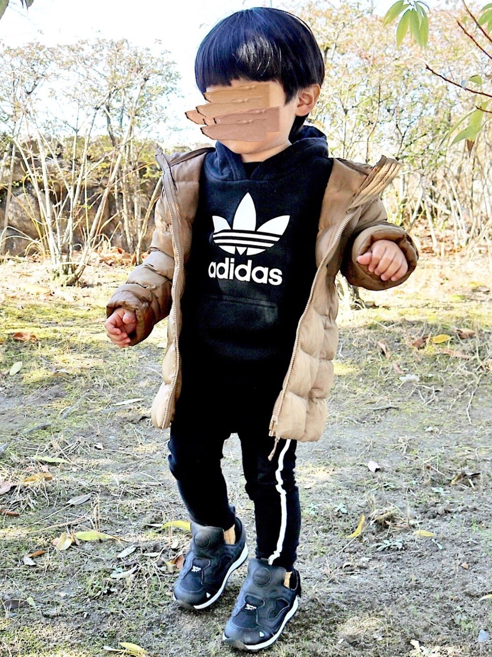 ブラウン系のその他アウター、ブラック系のパーカー、ブラック系のその他パンツを着用したキッズの冬コーディネートの1枚目の写真