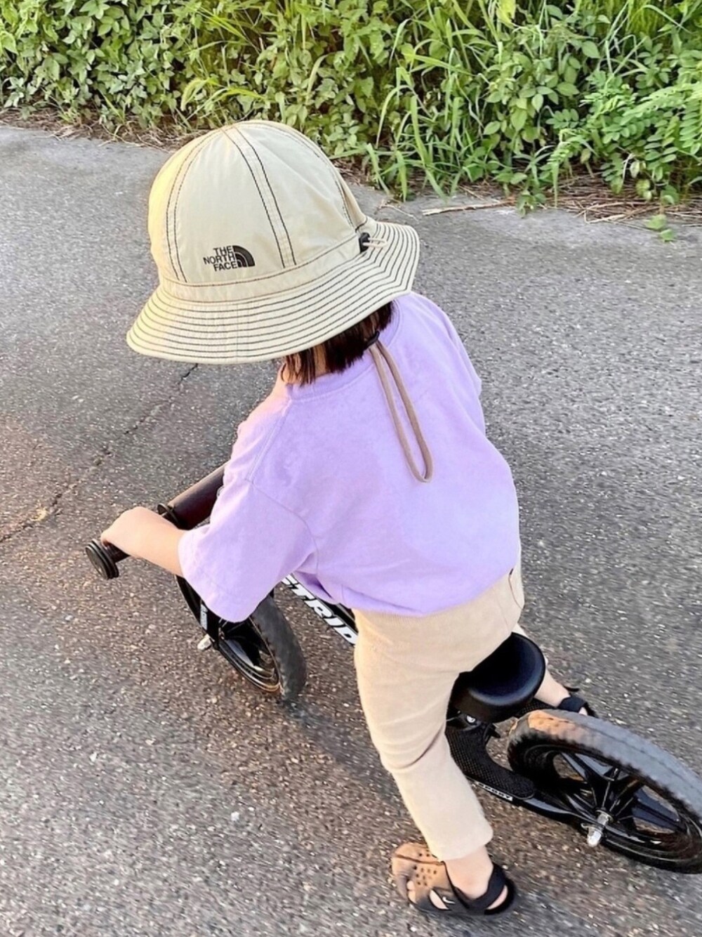 パープル系のTシャツ/カットソー、ベージュ系のパンツ、ブラック系のサンダルを着用したキッズの夏コーディネートの1枚目の写真