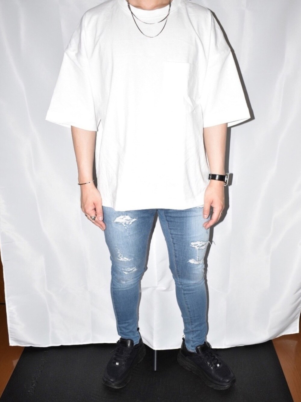 ホワイト系のTシャツ/カットソー、ブルー系のデニムパンツ、ブラック系のスニーカーを着用したメンズの春コーディネートの1枚目の写真