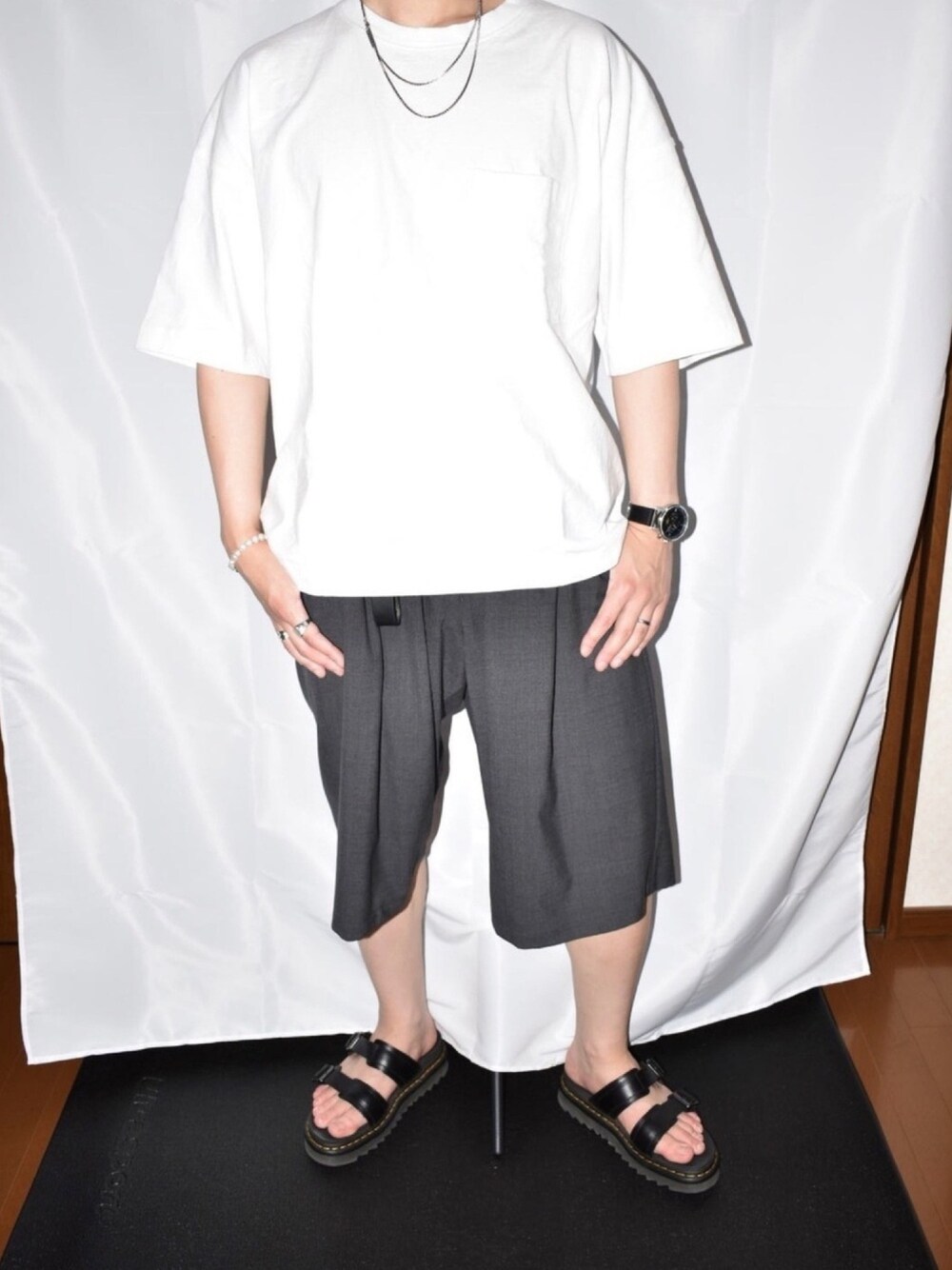 ホワイト系のTシャツ/カットソー、グレー系のその他パンツ、ブラック系のサンダルを着用したメンズの夏コーディネートの1枚目の写真