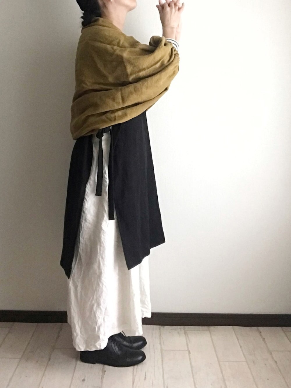 ブラック系のベスト、ホワイト系のワンピース/ドレス、イエロー系のカーディガン/ボレロを着用したレディースの秋コーディネートの1枚目の写真