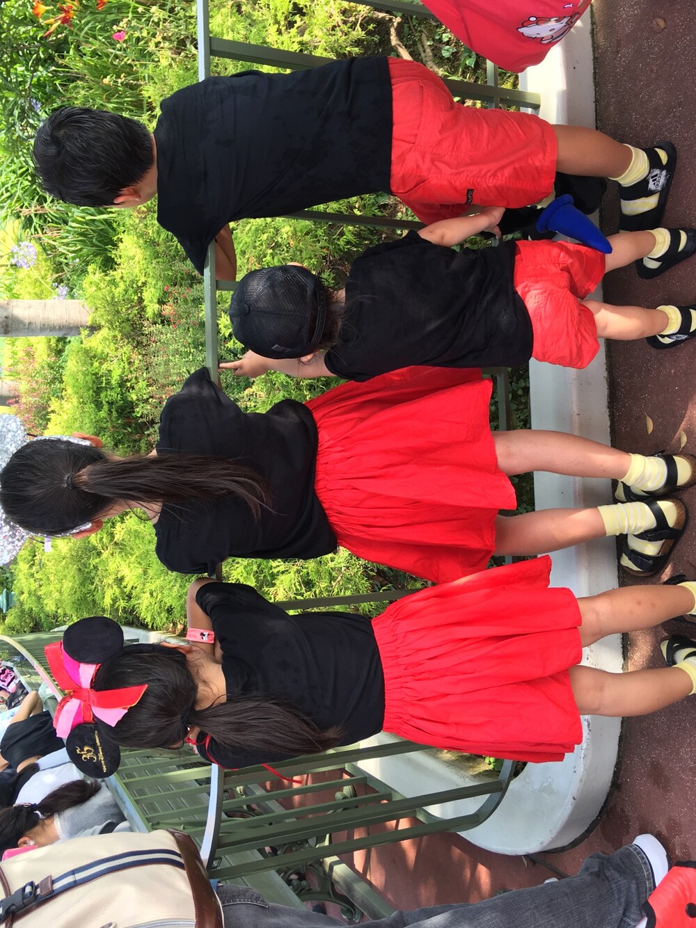 レッド系のスカート、レッド系のその他パンツ、ブラック系のTシャツ/カットソーを着用したキッズの夏コーディネートの1枚目の写真